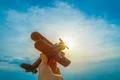 The hand with a toy plane on the background of the sunrise Photo