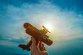 The hand with a toy plane on the background of the sunrise Photo