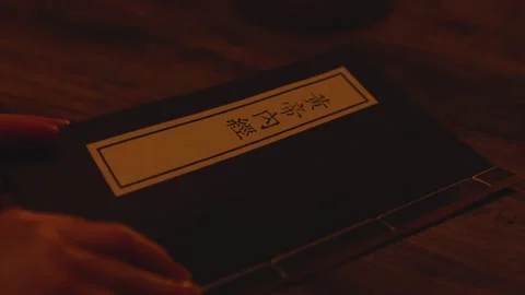 Hand Tracing Ancient Calligraphy Characters in Traditional Book on Wooden Table 動画素材 336548121