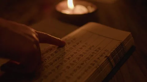 Hand Tracing Ancient Chinese Calligraphy on Manuscript Under Candlelight Stock Footage 336548252