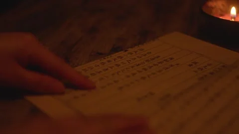 Hand Tracing Ancient Script Lines on Paper by Candlelight Vídeos de archivo 336548280