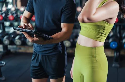 Hand of trainer holding and using tablet for schedule exercise training. Work Stock Photos