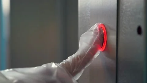 Hand in a transparent glove pushing the elevator button. Personal protection Stock Footage 140458103