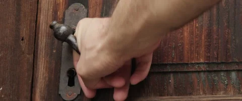 Hand tries to open old locked door 4K zoomout scope video Stock Footage 310532197