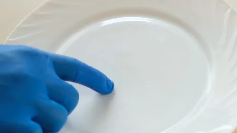 A hand trying to clean the adhered particles of food from a plate Stock-Footage 115265195