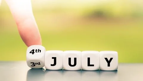 Hand tuns dice and changes the date "3rd of July" to "4th of July". Stock Photos