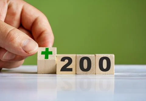 The hand turn wooden block with plus sign and set text "+200" Stock-Fotos