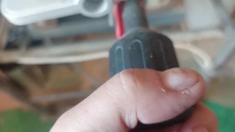 Hand turning a black plastic textured adjustment knob on a workshop machine Stock Footage 335647265