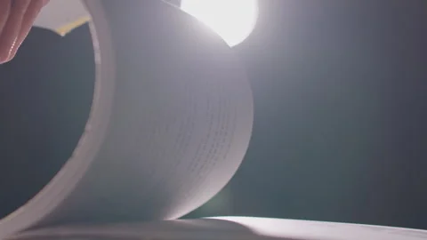 Hand Turning Book Page Under Bright Spotlight, Close-up Shot 库存影片 335472446