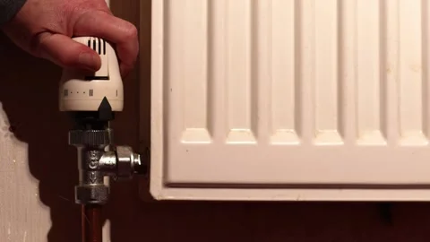 Hand turning on central heating radiator Stock Footage 260921172