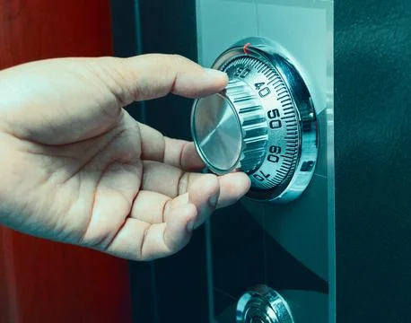 Hand turning code number on safe box Stock Photos