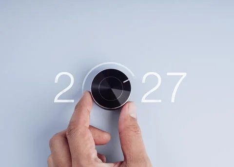 Hand turning a control dial toward maximum performance with 2027 new year n.. Stock-Fotos