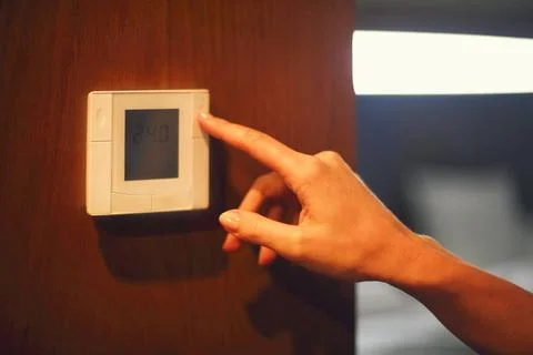 Hand turning on digital climate control Hand turning on digital climate co... Foto stock