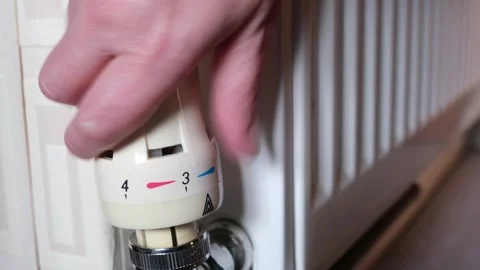 Hand Turning Down Thermostatic Radiator Valve to Save Energy Video stock 328512243