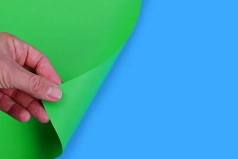 Hand turning empty page of green paper. Stock Photos