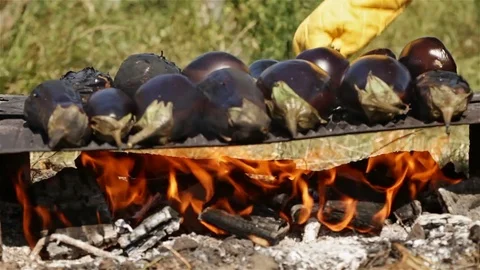 Hand turning a few baking eggplants on open fire 스톡 동영상 82797780