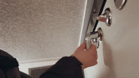 Hand turning key in lock, closeup of keys hanging then inserted, low angle Stock Footage 337451836
