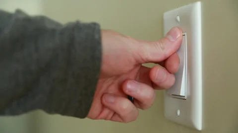 A hand turning on a light switch Stock Footage 32942076