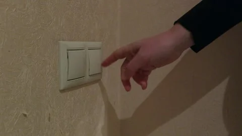 Hand turning off light switch on textured wall Vidéo 341559422