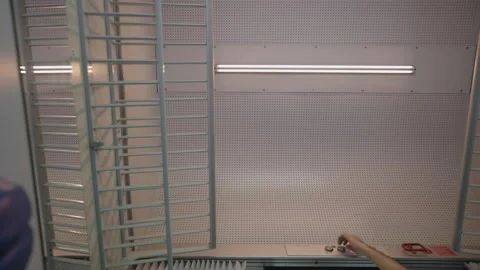 Hand turning on a long fluorescent light tube in a workshop Stock Footage 332277601