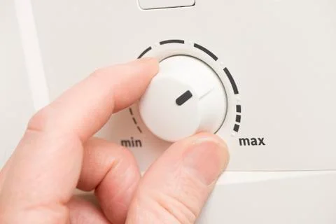 Hand Turning a Min Max Level Dial Foto stock