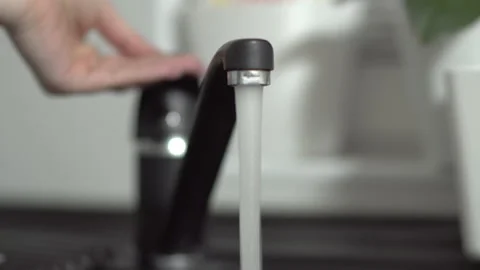 Hand turning modern black granitte tap on and off Video stock 136975587
