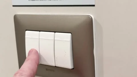Hand Turning Off Modern Triple Light Switch on Wall Stock Footage 320159416