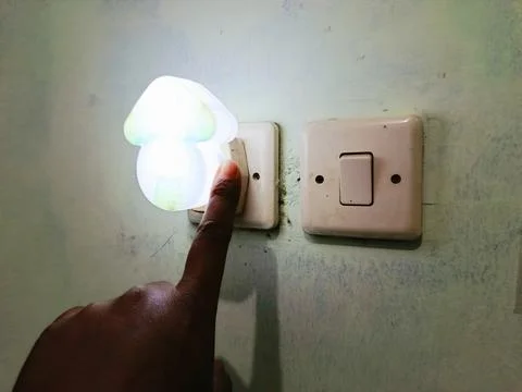 Hand Turning On Night Light Switch in Room, Finger Pressing Electrical Switch wi Stock Photos