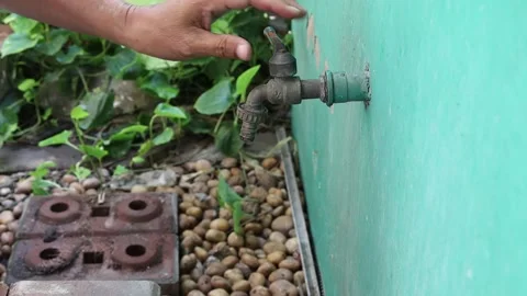 Hand is turning on old faucet for checking by opening water flowing Stock Footage 148037533