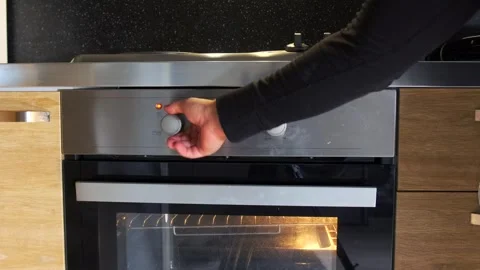 Hand turning oven knob close-up view, selecting cooking program on control 動画素材 333649273