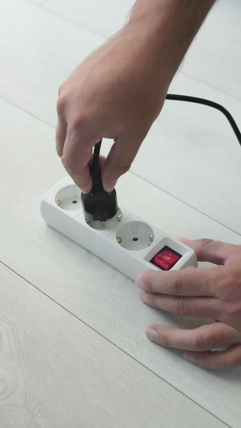 Hand turning on power strip and plugging in cable, top view, vertical video Stock Footage 344660411