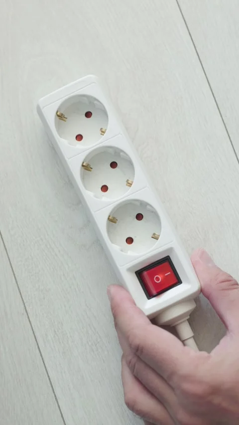 Hand turning on power strip switch and plugging in cable, top view, vertica.. Stock Footage 344660408