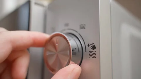 Hand turning the power switch on a microwave oven, close-up Stock Footage 324698480