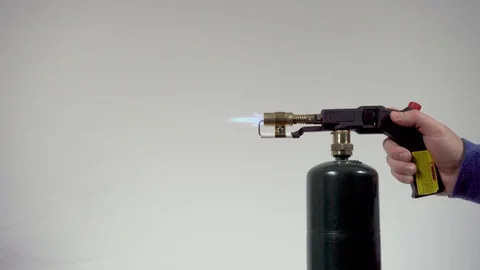 A Hand Turning on propane torch on high on  a white Background Stock Footage