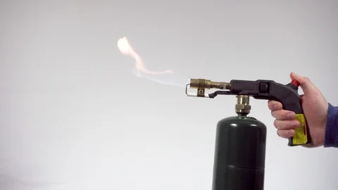 A Hand Turning on propane torch on a white Background Stock Footage 98618746