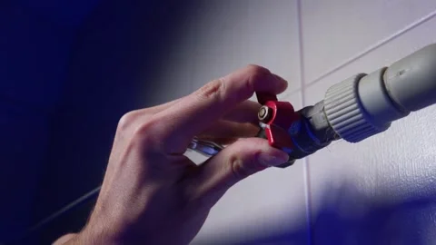 Hand Turning Red Ball Valve to Control Residential Water and Heating System Stock Footage 339211725