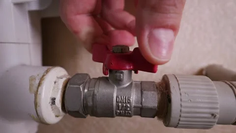 Hand Turning Red Ball Valve on Heating Pipe in Home Radiator System Stock Footage 339212200