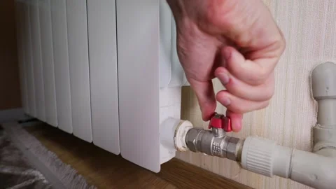 Hand Turning Off Red Ball Valve on Home Central Radiator Heating Pipe Stock Footage 339212759