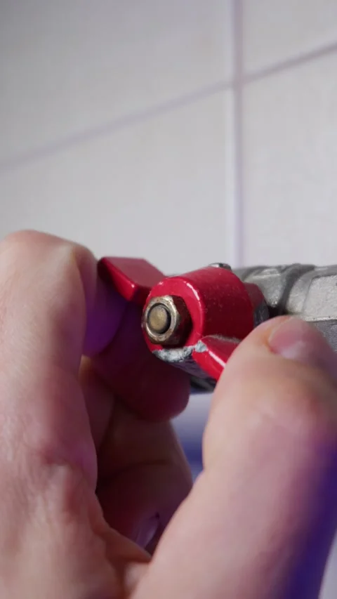 Hand Turning Red Lever Ball Valve to Shut Off Water or Heating Supply Stock Footage 339213692