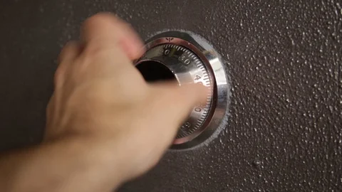 Hand turning a safe combination lock Stock Footage 86894576