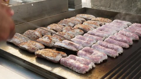 Hand turning sausages on the grill Stock Footage 314857819