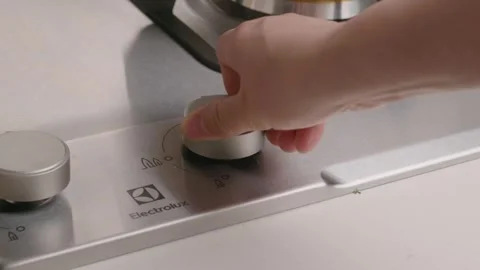 Hand Turning Silver Control Knob on Stainless Steel Electrolux Stove Top Video stock 336563233