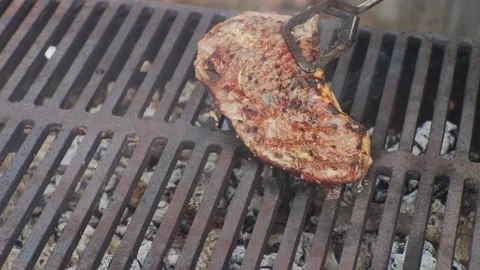 Hand turning steak on the grill  库存影片 146791984