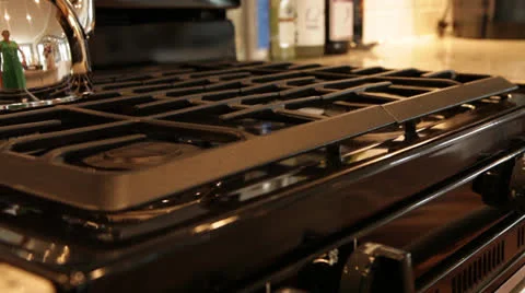 Hand Turning on stove, with kettle reflection, close-up Video stock 25912746