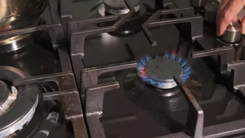Hand turning stove knob close-up view, igniting gas burner with piezo spark and Stockbeeldmateriaal 333649327