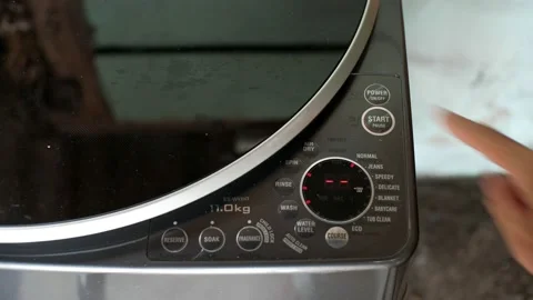 A hand turning the switch of a washing machine on and start. Stock Footage 139186104