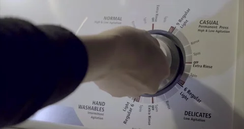 A hand turning the switch of a washing machine to different mode. 4K Video stock 145090665