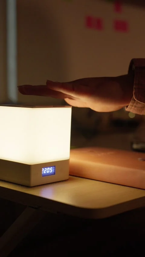 Hand Turning On Touch Bedside Lamp with Digital Clock Stock Footage 344948264