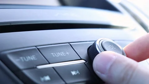 Hand turning volume button of a car audio system in the car Stock Footage 221270098