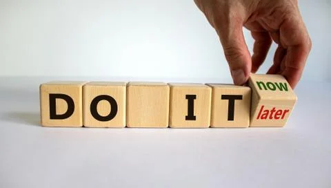 Hand turns a cube and changes the expression 'do it later' to 'do it now'. Be Stock Photos